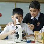 雅加达英华学校的学生看显微镜做实验