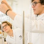 博苏蕾高山学院的两个高中男生在科学实验室拿着试管做实验