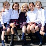 东京英国学校的5个小女孩坐在室外的长椅上