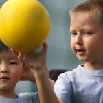 加拿大学院的小朋友玩黄色的球