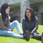戈代加讷尔国际学校的2个女孩坐在草地上聊天