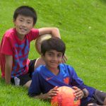 戈代加讷尔国际学校的2个小男孩在草地上拿着球