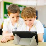 视野英语学校的2个小男孩玩iPad
