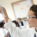 国王学校阿尔巴沙分校的学生在化学课上观察试管里的液体