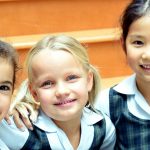 国王学校迪拜分校的3个小女孩坐在室内楼梯上