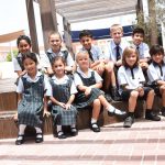 国王学校迪拜分校的学生穿着校服坐在室外