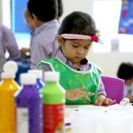 萨法社区学校的幼儿园小朋友在美术课上用手指涂色