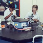 萨法社区学校的学生看显微镜做实验