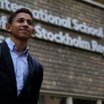 斯德哥尔摩地区国际学校的男孩站在学校校名前