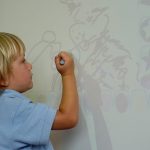 马尼拉国王学校的小男孩在白板上画画