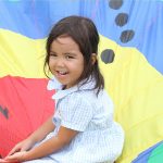 马尼拉国王学校的小女孩坐在彩色的布面上
