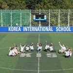 韩国国际学校板桥校区的学生坐在运动场上