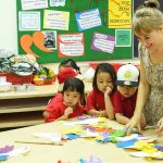 胡志明市英国越南国际学校的老师在教室里和学生一起做手工