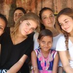 开罗美国学校的学生们和一个小女孩子在一起