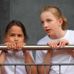 约翰·F·肯尼迪国际学校的2个女学生趴在栏杆上聊天