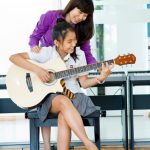 奥林匹亚学校的老师教学生弹吉他