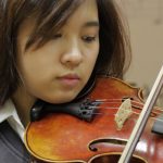 英华国际学校的学生拉小提琴