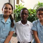 加纳国际学校的3个学生坐在教学楼外