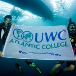英国大西洋世界联合学院的学生带着校旗潜水